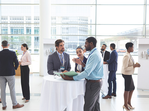 Business people discussing over documents at table during a seminar